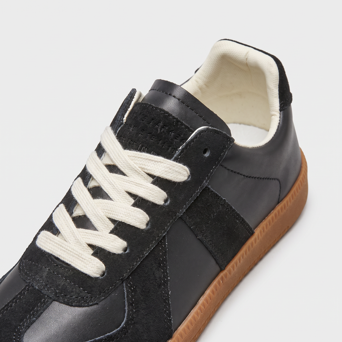 Sznurowanie, język i wyściełany kołnierz sneakersów retro
