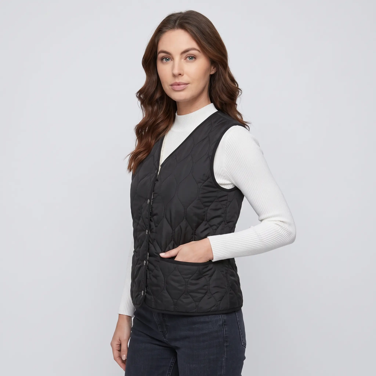 Women's quilted puffer vest in Black, three-quarter view with welt pocket